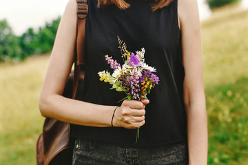 Canvas Print - stylish hipster woman with backpack gathering and holding  wildf