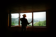 Silhouette Of Woman In Sunshine At Big Wooden Window With View O