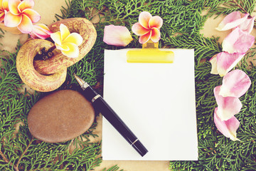 Wall Mural - Nature background of plumeria or frangipani with blank paper note pad and pen
