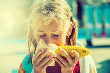 Cute Little Girl Eating Sweet Corn.