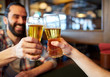 © Syda Productions - happy male friends drinking beer at bar or pub