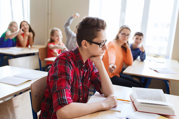 Canvas Print - classmates laughing at student boy in school