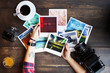 © veles_studio - Women's hands holding printed photos. Dressed in red shirt, lotus tattoo on arm. On old wooden table scattered photos, two old medium format film camera, glass of juice, cup of coffee. Point of view