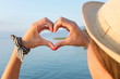 © creativefamily - Woman hands making heart shape at the beach