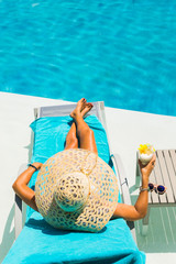 Canvas Print - Woman at the poolside with pina colada cocktail