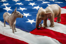 Democrats Vs Republicans Are Facing Off In A Ideological Duel On The American Flag. In American Politics US Parties Are Represented By Either The Democrat Donkey Or Republican Elephant