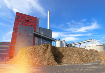 Wall Mural - bio power plant with storage of wooden fuel against blue sky