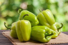 Pile Green Pepper On A Wooden Table With Blurred Background