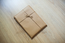 Wrapped Gift Kraft Paper On A Wooden Background