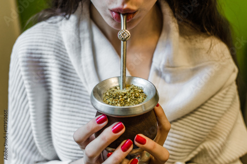Fotografie, Tablou Young woman drinking traditional Argentinian yerba mate tea from a calabash gourd with bombilla stick