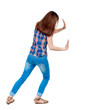 © ghoststone - back view of woman pushes wall.  Isolated over white background. Rear view people collection. backside view of person. Girl in plaid shirt shoves something in the side.