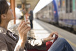 © plprod - femme assise qui fume sur un quai de gare