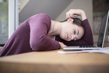 Tired Young Woman Sleeping At Desk