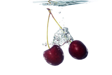 Wall Mural - Cherries falling into water with splash