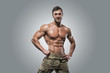 © bondarchik - Muscular athlete bodybuilder man on a gray background