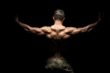 Poster - Muscular athlete bodybuilder man on a dark background