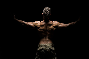 Poster - Muscular athlete bodybuilder man on a dark background