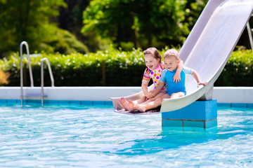 Wall Mural - Kids on water slide in swimming pool