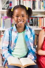 Schoolgirl reading a book in library