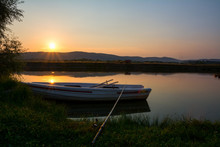 Fishing Rod On White Wooden Rowing Boat On A Beautiful Fishing Lake At Sunset