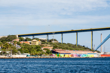 Wall Mural - Curaco Bridge with Colorful Buildings and Blue Channel