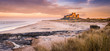 Golden Bamburgh Castle panorama, on the Northumberland coastline, bathed in late afternoon golden sunlight