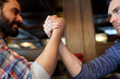 © Syda Productions - close up of men arm wrestling at bar or pub