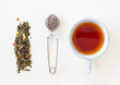 © vwpix - Cup of tea, loose leaf and tea strainer on white background