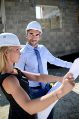 Wall Mural - cute young woman architect with handsome foreman in building industry construction site