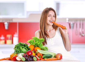 Woman eating carrot in the kitchen