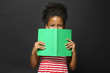 © Africa Studio - Cute girl reading book on grey background