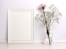 White Frame Mockup With Flowers. Front Viw Of The Empty White Frame