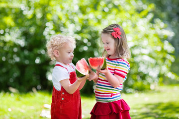 Kids eating watermelon in the garden