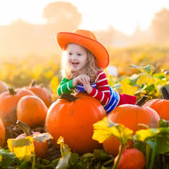 child playing on pumpkin patch