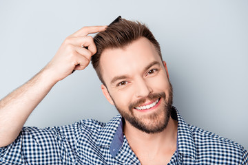 Wall Mural - Handsome happy young man combing his hair