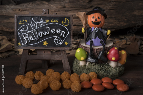 Pumpkin head jack (Jack-o-lantern) in witch suit sitting on a tree with hallo...