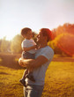 © guas - Happy father holding on hands child son warm autumn evening, sun