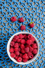 Wall Mural - plate with ripe raspberries stands on lace crocheted doily