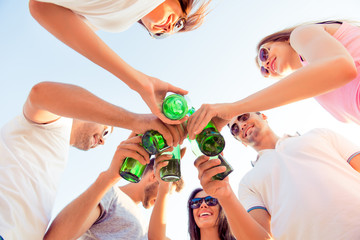 Canvas Print - cheers! joyful boyfriends and girlfriends clinking bottle and en