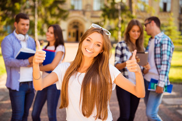 Canvas Print - excited happy girl standing near university and her friends and