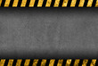 Grunge dark grey background with black and yellow warning stripes