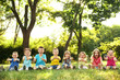 © Africa Studio - Happy kids sitting on grass in park