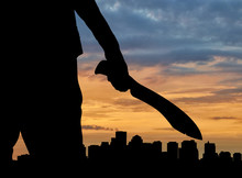 Silhouette Of Man Holding Knife During Sunset