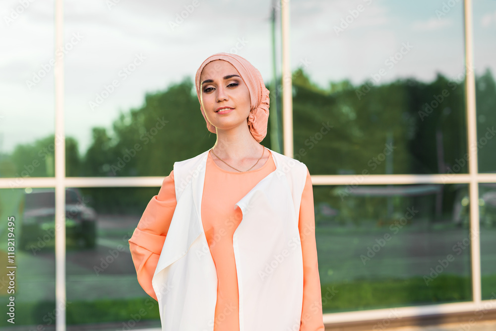 Young woman wearing hijab head scarf in city. Stock Photo | Adobe Stock