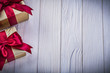 Wrapped giftboxes with tied bows on wooden board copyspace holid
