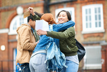 Young Adult College Students Congratulating Each Others Exam Results On Campus