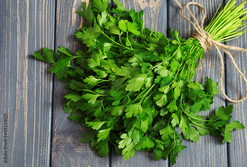 Cuadros en Lienzo Fresh bunch of parsley closeup on wooden table. Top view
