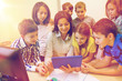 © Syda Productions - group of kids with teacher and tablet pc at school