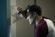 © Connect Images - Man leaning against window looking out