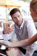 © Connect Images - Mature man and woman sitting outside cafe, having discussion